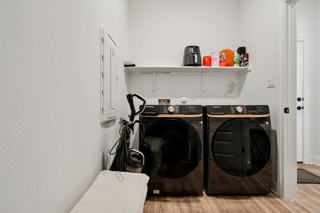 Washroom with washer and dryer and wood finished floors | Image 13