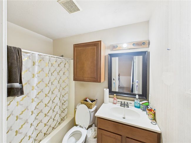 Bathroom featuring vanity and shower / bathtub combination with curtain | Image 9