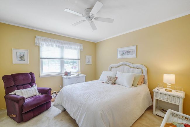 Carpeted bedroom with crown molding and a ceiling fan | Image 13