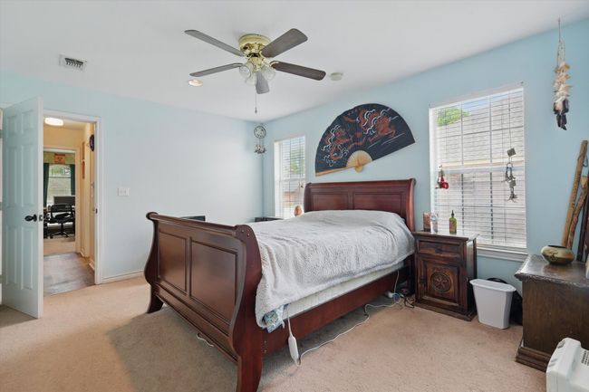 Bedroom with visible vents, light colored carpet, baseboards, and ceiling fan | Image 19