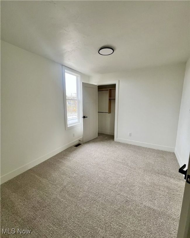 Unfurnished bedroom featuring light carpet, a closet, and baseboards | Image 16
