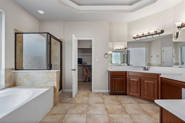 Bathroom featuring vanity, a stall shower, a bath, a spacious closet, and ornamental molding | Image 22