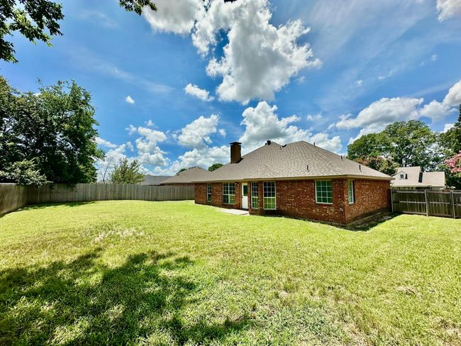 Rear view of property with a chimney, a fenced backyard, and brick siding | Image 23