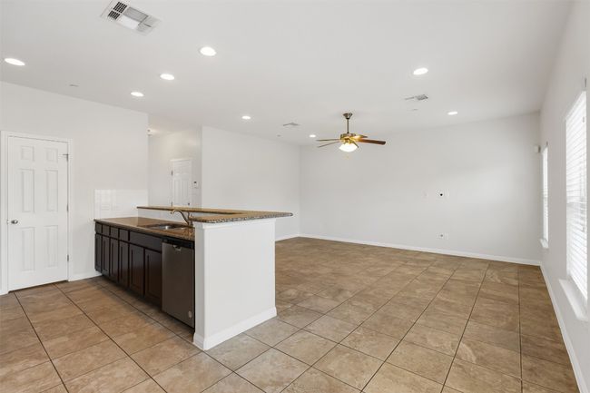 Kitchen featuring stainless steel dishwasher, a ceiling fan, a peninsula, recessed lighting, and light tile patterned floors | Image 10
