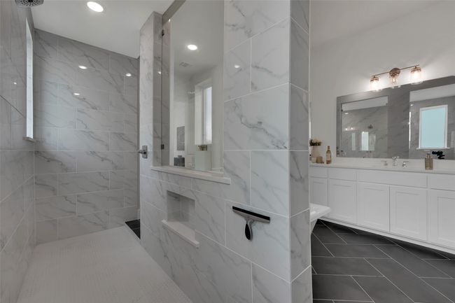 Bathroom with walk in shower, tile patterned floors, vanity, and tile walls | Image 30