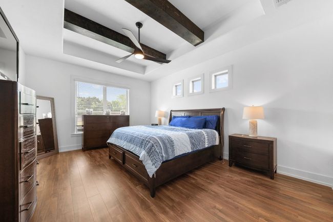 Bedroom with baseboards, beamed ceiling, a ceiling fan, and wood finished floors | Image 18