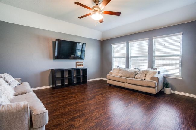 Living room featuring dark wood-type flooring, a wealth of natural light, and ceiling fan | Image 4