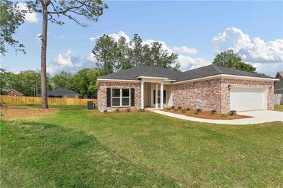 View of front of home with central AC, a front yard, and a garage | Image 2