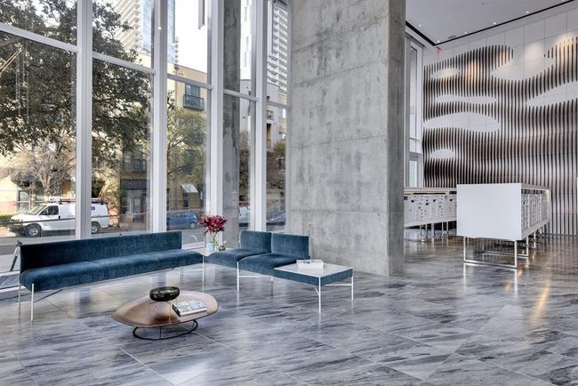 Common area with a high ceiling and a wall of windows | Image 15