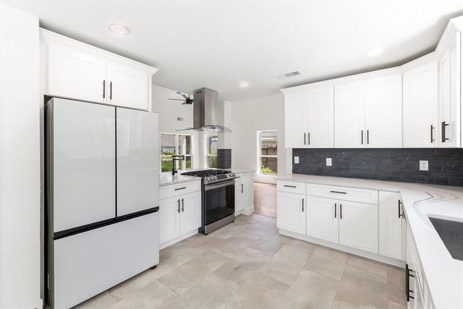 Kitchen features abundant counter space and cabinets, updated appliances, and flooded with natural light. | Image 10