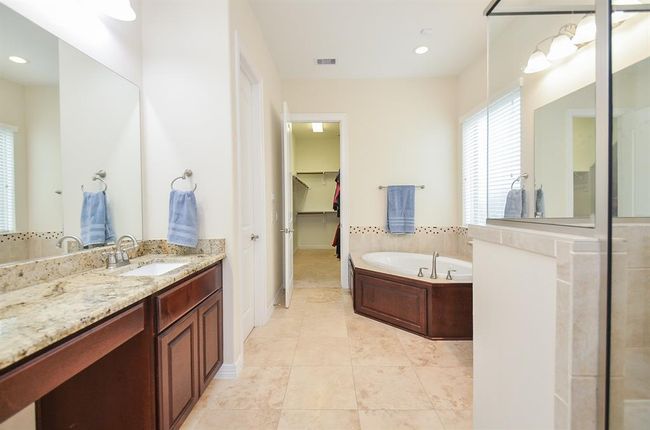 Primary bathroom with dual vanities and separate shower and jetted tub. | Image 21