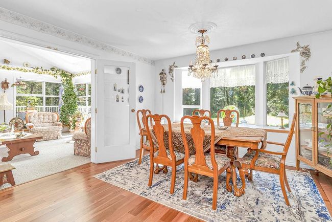 Dining room with a chandelier and light wood finished floors | Image 9