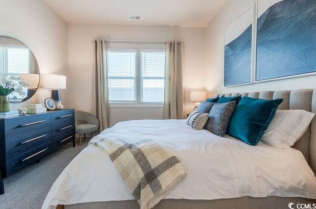 Bedroom with multiple windows, visible vents, and dark carpet | Image 14