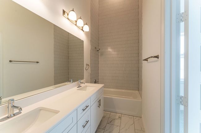 Bathroom featuring a sink, double vanity, marble finish floor, and tub / shower combination | Image 11