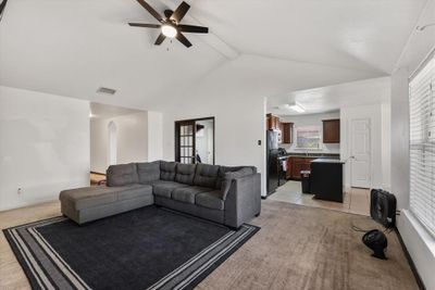 Carpeted living room featuring lofted ceiling with beams and ceiling fan | Image 3