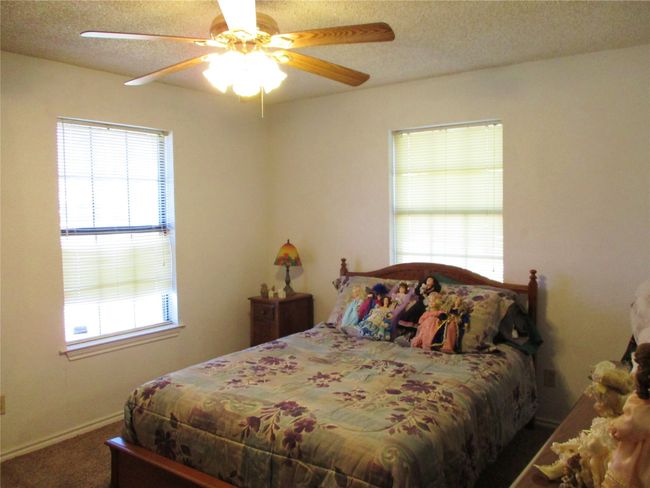 Carpeted bedroom featuring ceiling fan and a textured ceiling | Image 12