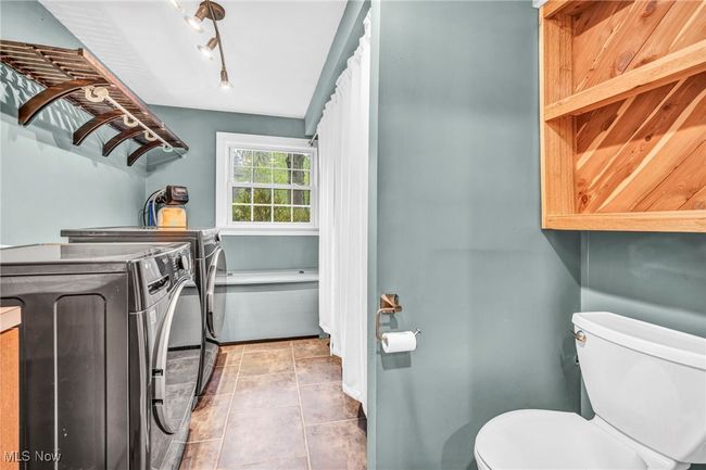 Laundry room featuring washing machine and clothes dryer and tile patterned flooring | Image 28