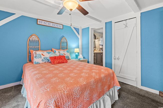 Carpeted bedroom with ceiling fan, beam ceiling, and ensuite bathroom | Image 16