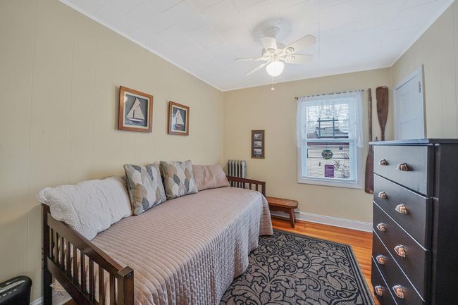 Bedroom featuring radiator, ornamental molding, baseboards, ceiling fan, and light wood-style flooring | Image 17