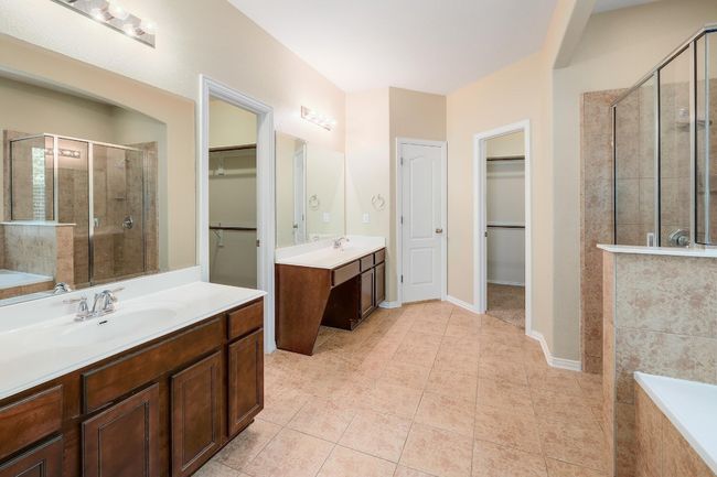 The ensuite bath is designed for ultimate relaxation, with separate vanities, a soaking tub, and a step-in shower | Image 23