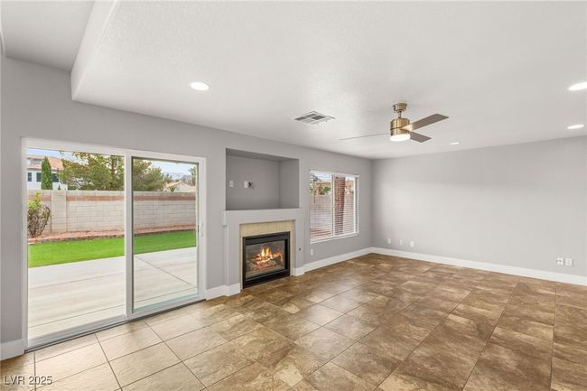 Unfurnished living room featuring baseboards, a tiled fireplace, visible vents, and recessed lighting | Image 15
