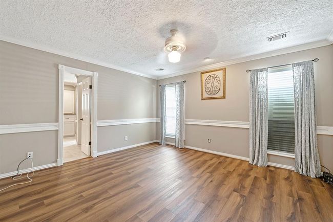 Retire at night to your luxurious downstairs primary suite boasting crown molding and chair rail. | Image 17