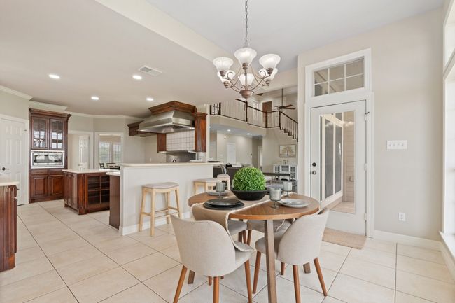 View of breakfast area looking into the commercial grade kitchen. Door shown leads to the large covered patio area. | Image 16