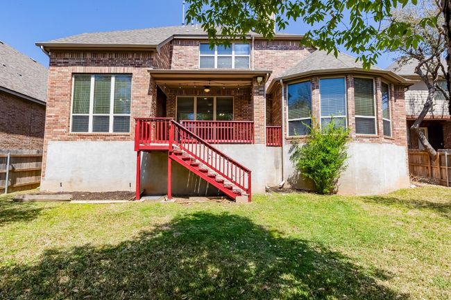 Rear view of house featuring a lawn, stairs, fence, and brick siding | Image 36