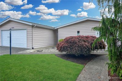 Welcome home to your home on a lake. A happy gurgling creek runs to the right side where the front door is. The back door is on the left side next to the garage door and patio. | Image 1