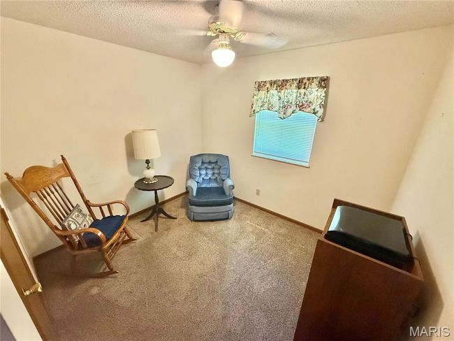 Living area featuring a ceiling fan, carpet, and a textured ceiling | Image 25