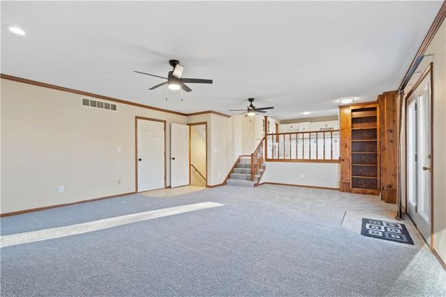 Unfurnished living room with stairway, ceiling fan, light carpet, and visible vents | Image 18