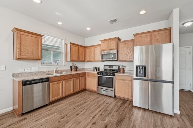 Kitchen with stainless steel appliances, light wood-style flooring, and recessed lighting | Image 12