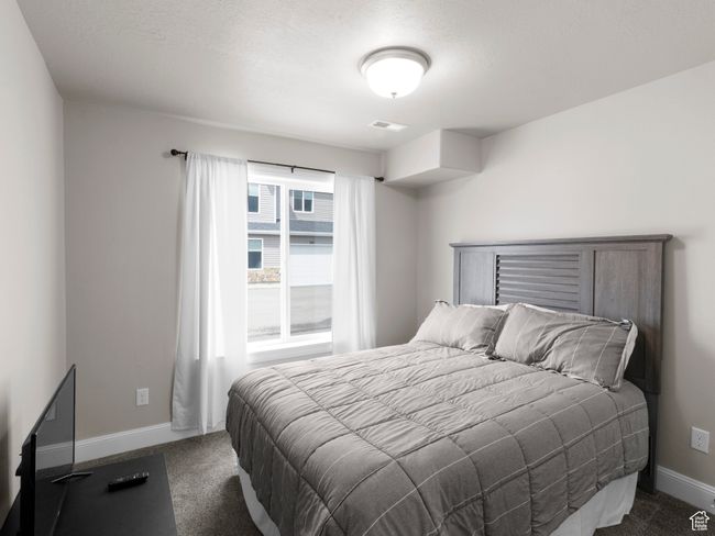 Bedroom with baseboards, visible vents, and dark carpet | Image 15