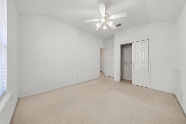 Unfurnished bedroom with light carpet, visible vents, a closet, and vaulted ceiling | Image 16
