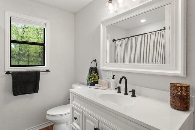 Full bath featuring toilet, vanity, and curtained shower | Image 29