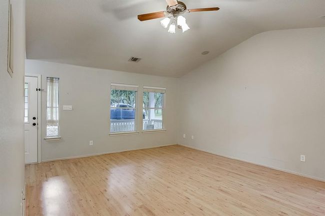 Unfurnished room featuring light wood-style floors, vaulted ceiling, ceiling fan, and baseboards | Image 4