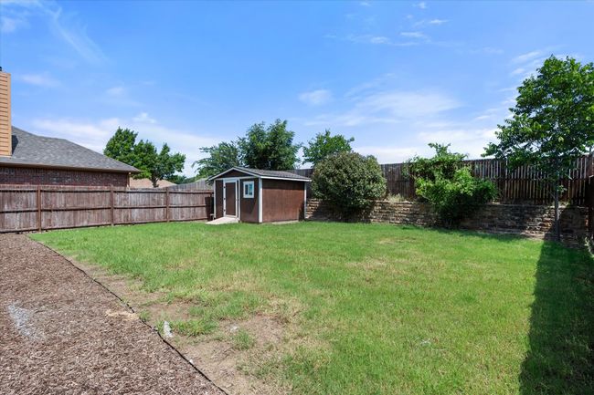 Fenced backyard with a storage unit | Image 36