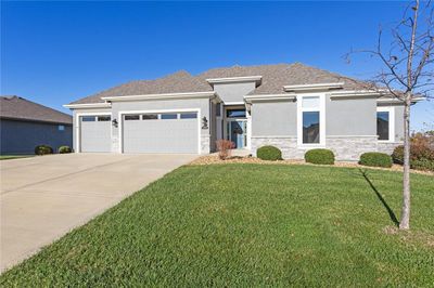 Custom built for ease of access with zero entry from front door and garage. 4 sided stucco exterior with stylish front elevation, stone trim, and wonderful landscaping. Inground sprinkler system | Image 1