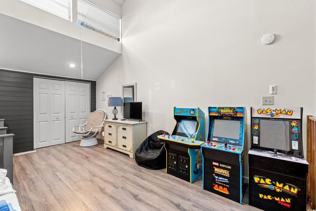 Game room with wood finished floors and a towering ceiling | Image 22