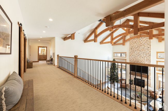 Hall featuring high vaulted ceiling, beam ceiling, light colored carpet, and recessed lighting | Image 17