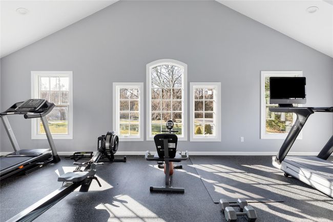 Exercise room with a wealth of natural light and baseboards | Image 46