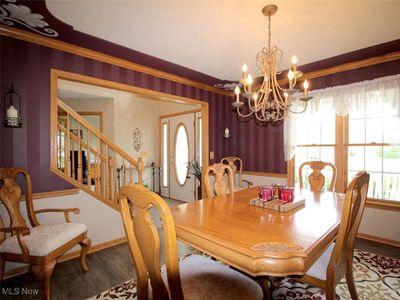 Dining space featuring a notable chandelier, hardwood / wood-style floors, and crown molding | Image 3