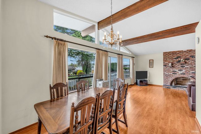 Dining space with a chandelier, a brick fireplace, and light wood-style floors | Image 8