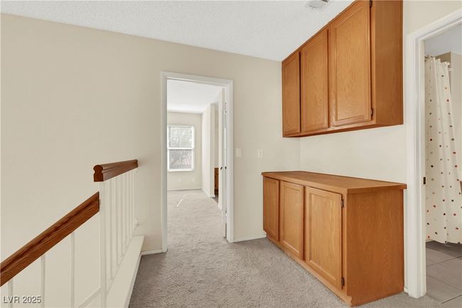 Corridor with baseboards, light colored carpet, a textured ceiling, and an upstairs landing | Image 21