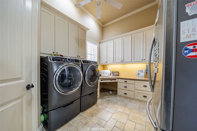 Laundry room with cabinets, independent washer and dryer, ceiling fan, and crown molding | Image 19