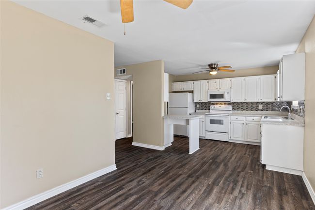 Kitchen with white appliances, a sink, visible vents, light countertops, and tasteful backsplash | Image 35