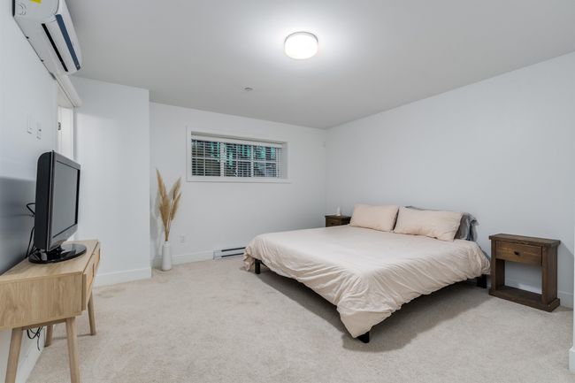 Bedroom featuring a wall unit AC, baseboards, a baseboard heating unit, and light carpet | Image 16