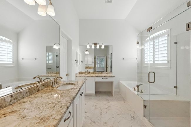 Walk in shower, make up vanity, new tile flooring, granite countertop, large soaking tub. | Image 21