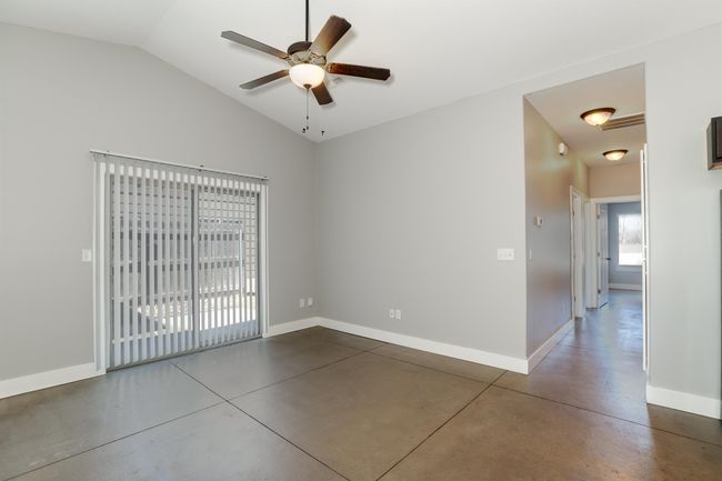 Unfurnished room with lofted ceiling, concrete floors, and ceiling fan | Image 12