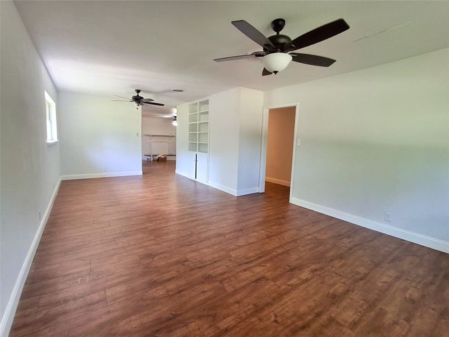 Unfurnished room with a ceiling fan, dark wood-style flooring, and baseboards | Image 14